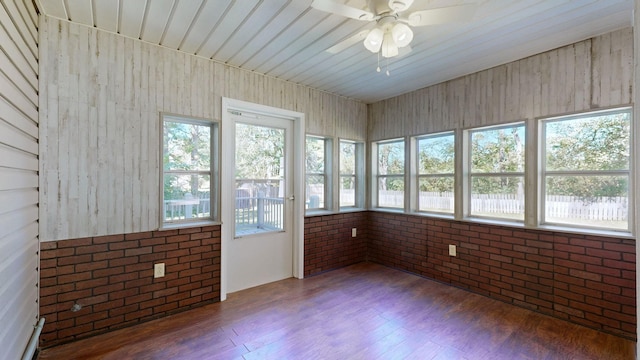 unfurnished sunroom with ceiling fan and a healthy amount of sunlight