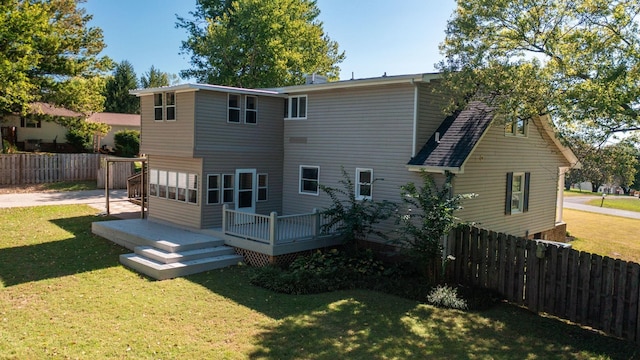 rear view of house featuring a yard and a wooden deck