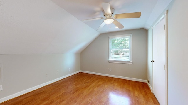 additional living space with ceiling fan, light wood-type flooring, and vaulted ceiling