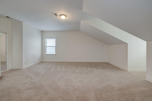 bonus room with light colored carpet and lofted ceiling