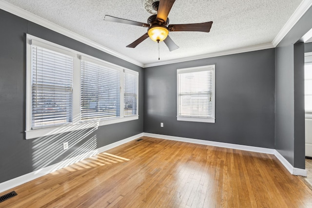 unfurnished room featuring hardwood / wood-style flooring, a wealth of natural light, and crown molding