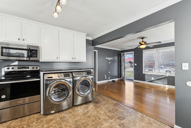 laundry room with a textured ceiling, washing machine and dryer, ceiling fan, and ornamental molding