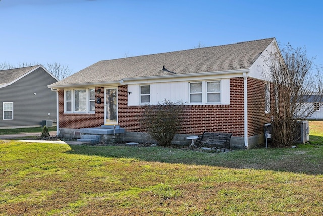 view of front of home with cooling unit and a front yard