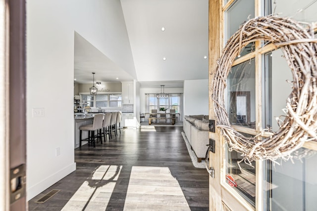 living room featuring dark wood-type flooring and high vaulted ceiling