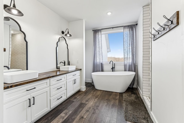 bathroom featuring a bathing tub, vanity, and wood-type flooring