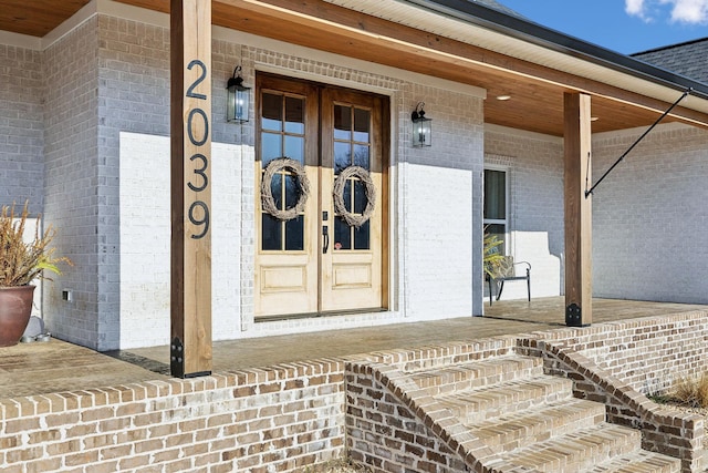 doorway to property with a porch and french doors