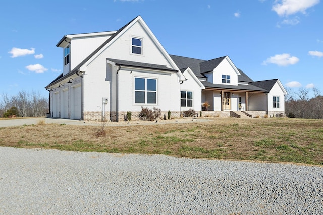 modern farmhouse style home with a porch and a garage