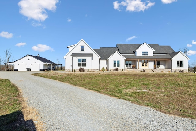 modern farmhouse featuring a porch, a garage, a front lawn, and an outdoor structure