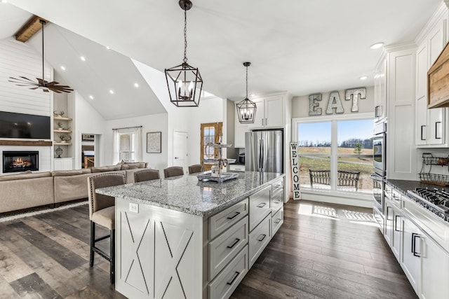 kitchen with a center island, stainless steel fridge, beamed ceiling, a kitchen bar, and white cabinetry