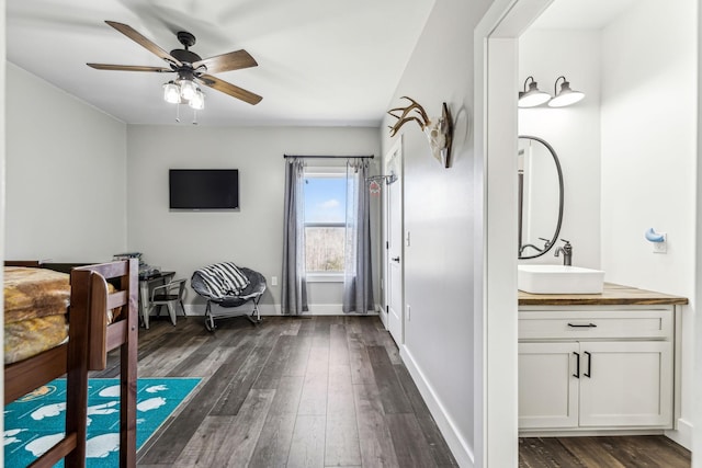 interior space featuring ceiling fan, sink, and dark wood-type flooring