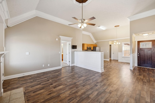 unfurnished living room featuring lofted ceiling, dark hardwood / wood-style floors, ornamental molding, and ceiling fan with notable chandelier