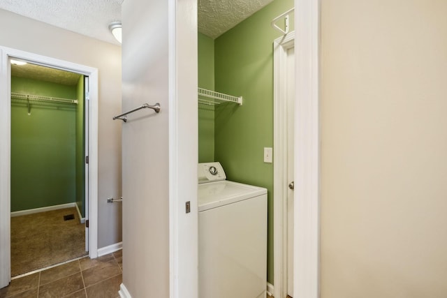 washroom featuring dark tile patterned floors, a textured ceiling, and washer / dryer