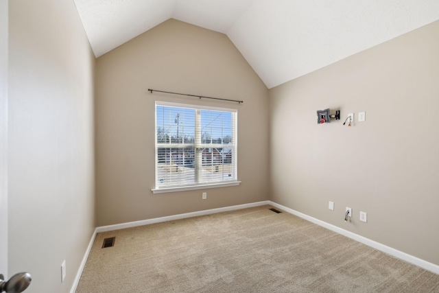 unfurnished room with light colored carpet and vaulted ceiling