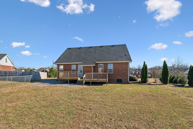 rear view of house with a deck and a yard