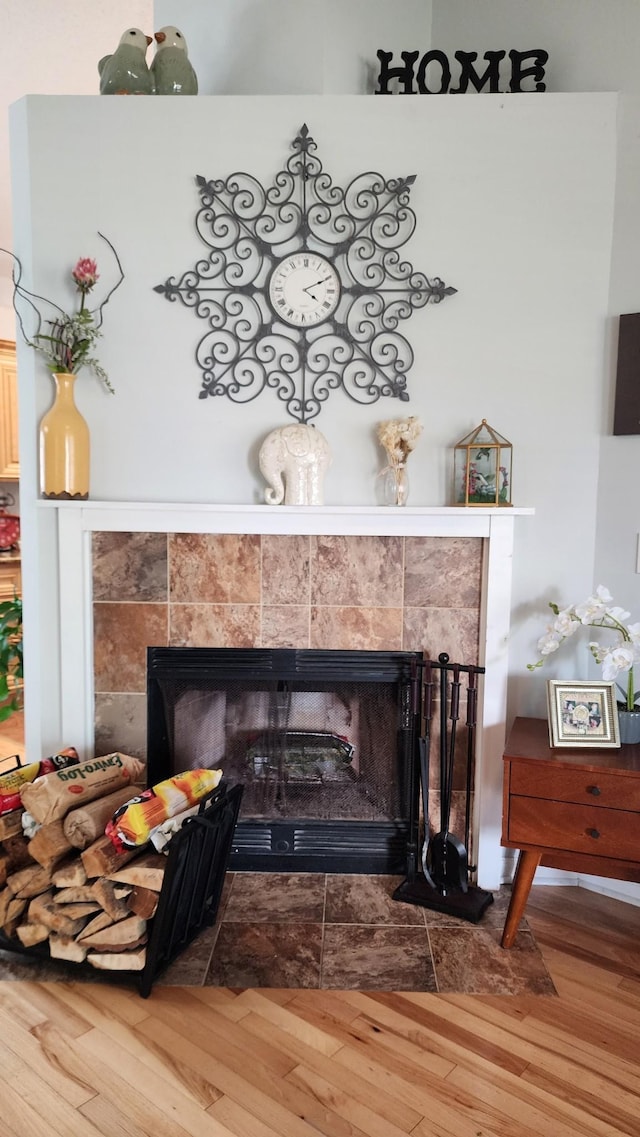 room details with a tile fireplace and hardwood / wood-style flooring