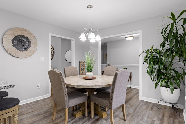 dining area featuring a notable chandelier and dark wood-type flooring