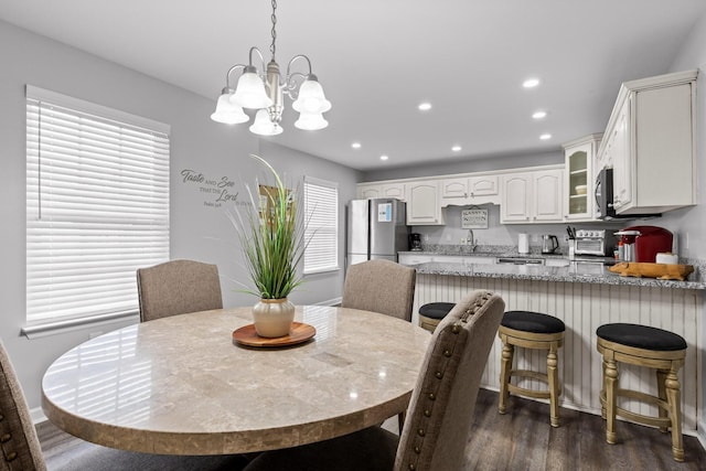 dining space featuring an inviting chandelier, dark hardwood / wood-style floors, and sink