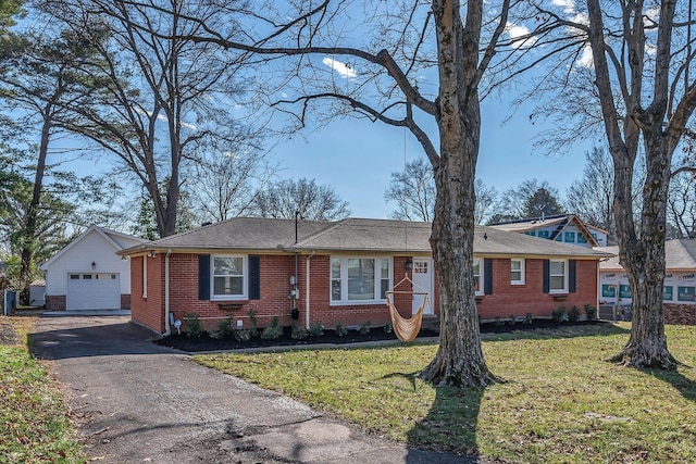 ranch-style house featuring driveway, brick siding, a front lawn, and a detached garage