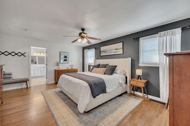 bedroom with light wood finished floors, baseboards, visible vents, and a ceiling fan