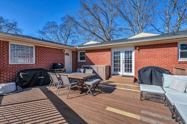 wooden deck with an outdoor living space, outdoor dining area, area for grilling, and french doors