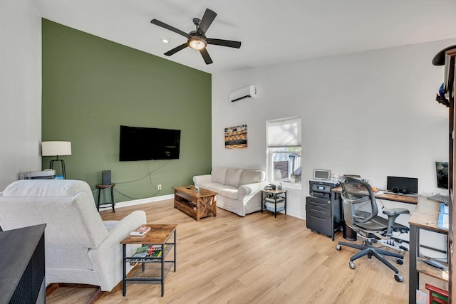 office featuring baseboards, a wall unit AC, lofted ceiling, ceiling fan, and light wood-type flooring