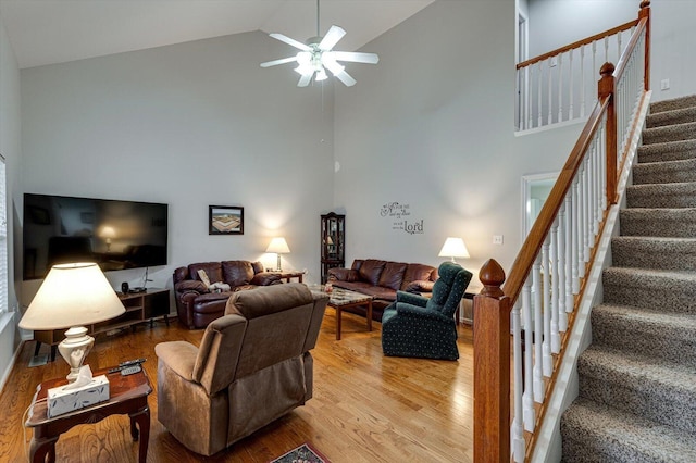 living room featuring light hardwood / wood-style floors, high vaulted ceiling, and ceiling fan