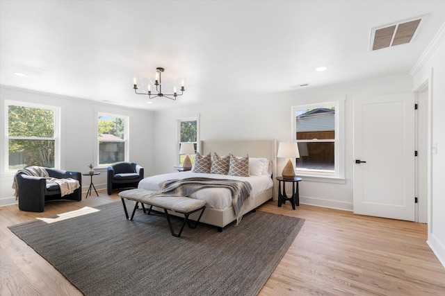 bedroom featuring a chandelier, light hardwood / wood-style flooring, and crown molding