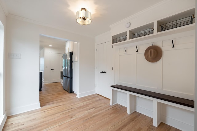 mudroom with light wood-type flooring, ornamental molding, and an inviting chandelier