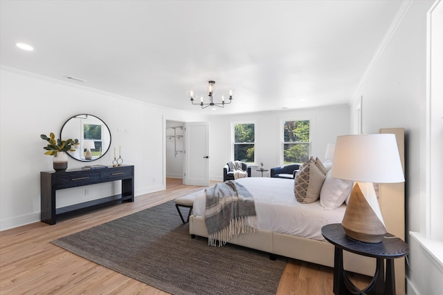 bedroom with crown molding, hardwood / wood-style floors, and an inviting chandelier