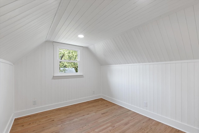 additional living space featuring lofted ceiling and light hardwood / wood-style flooring