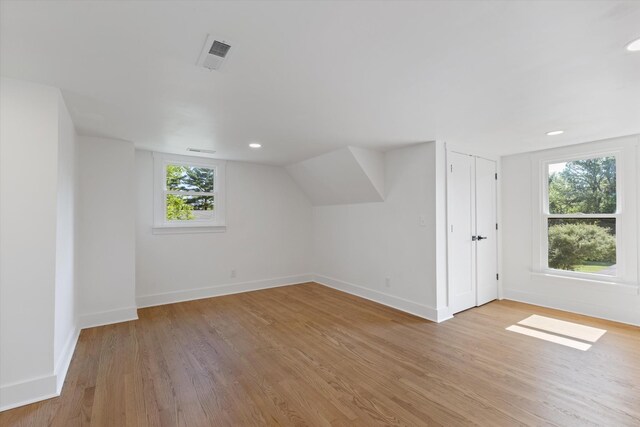 bonus room with vaulted ceiling, light hardwood / wood-style flooring, and a wealth of natural light