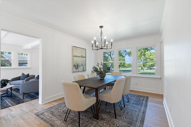 dining room featuring light hardwood / wood-style floors, crown molding, and an inviting chandelier