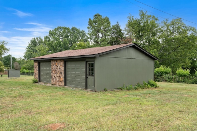 view of outdoor structure featuring a yard and a garage