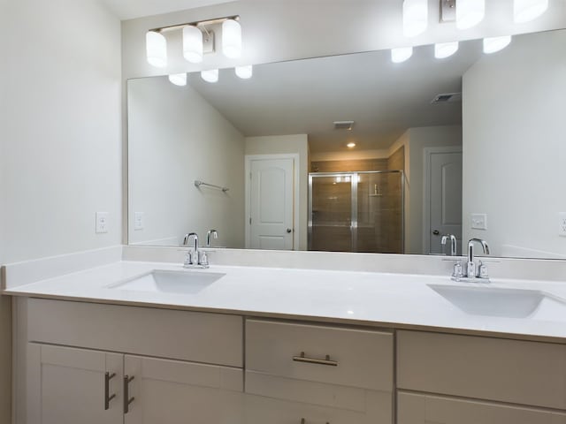 bathroom with vanity and a shower with door