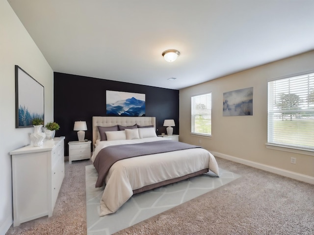 bedroom with light colored carpet and multiple windows