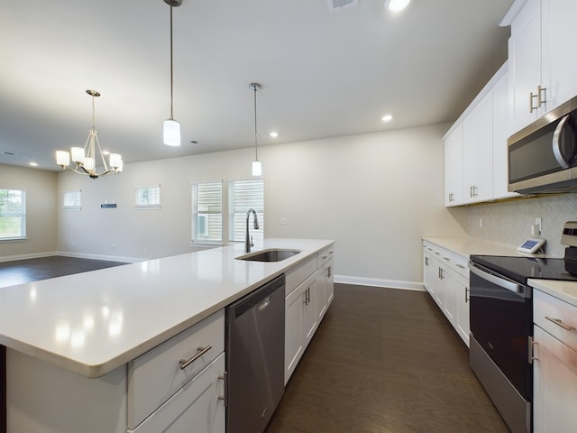 kitchen with white cabinets, a kitchen island with sink, sink, and appliances with stainless steel finishes