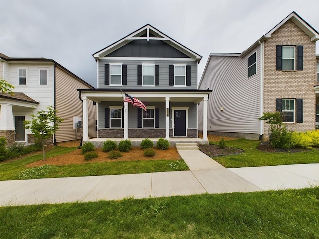 craftsman-style home featuring covered porch and a front yard