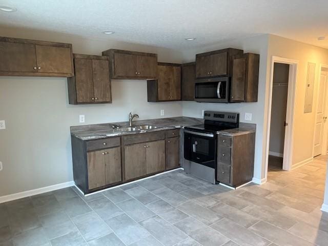 kitchen featuring dark brown cabinets, stainless steel appliances, and sink