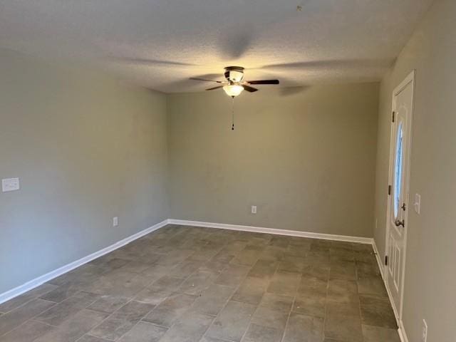 empty room with ceiling fan and a textured ceiling