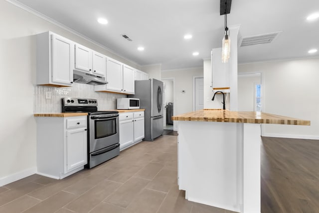 kitchen with pendant lighting, white cabinets, butcher block countertops, and stainless steel appliances