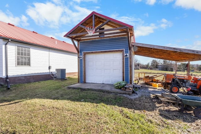 garage featuring central AC unit and a lawn