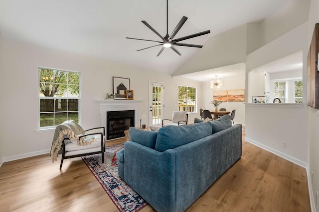 living room with light hardwood / wood-style flooring, vaulted ceiling, and a healthy amount of sunlight