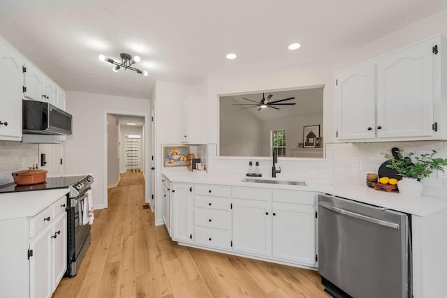 kitchen featuring decorative backsplash, sink, white cabinetry, and stainless steel appliances