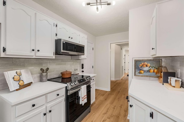 kitchen featuring white cabinets, a textured ceiling, stainless steel appliances, and tasteful backsplash