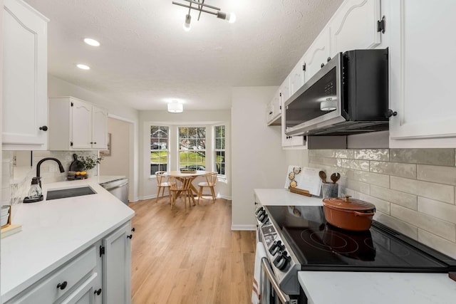 kitchen featuring white cabinets, sink, stainless steel appliances, and tasteful backsplash