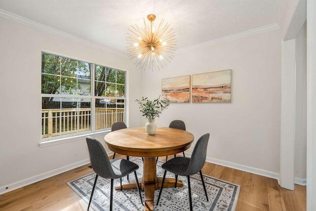 dining space with light hardwood / wood-style flooring, crown molding, and a notable chandelier