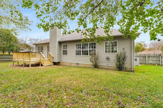 rear view of house with a yard and a wooden deck