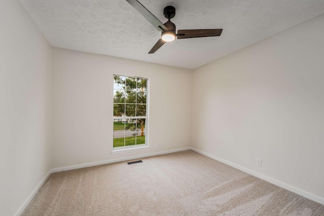 carpeted spare room featuring a textured ceiling and ceiling fan