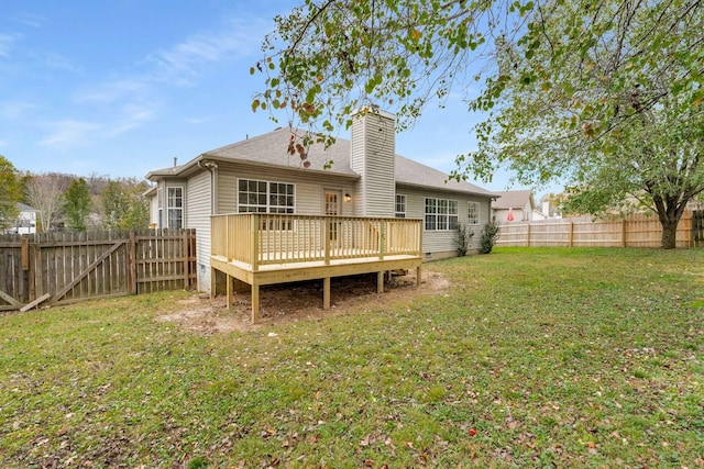 rear view of house with a yard and a wooden deck