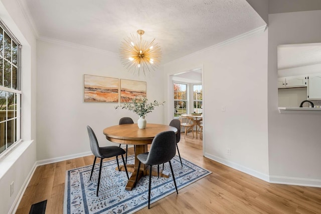 dining room with crown molding, a textured ceiling, and a notable chandelier